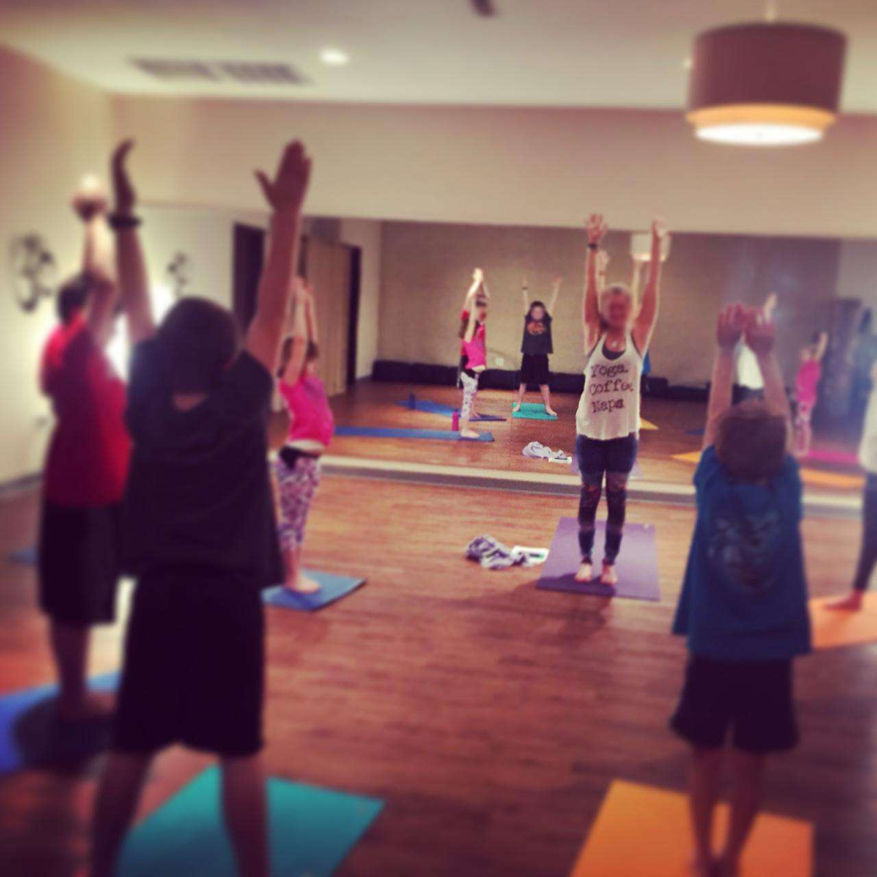 The Zin Yoga Studio — warm wood floors, colorful mats, pendant lamp